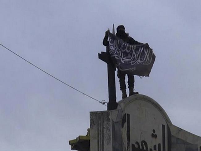 Ein Kämpfer der Al-Nusra-Front hisst Flagge in Idlib