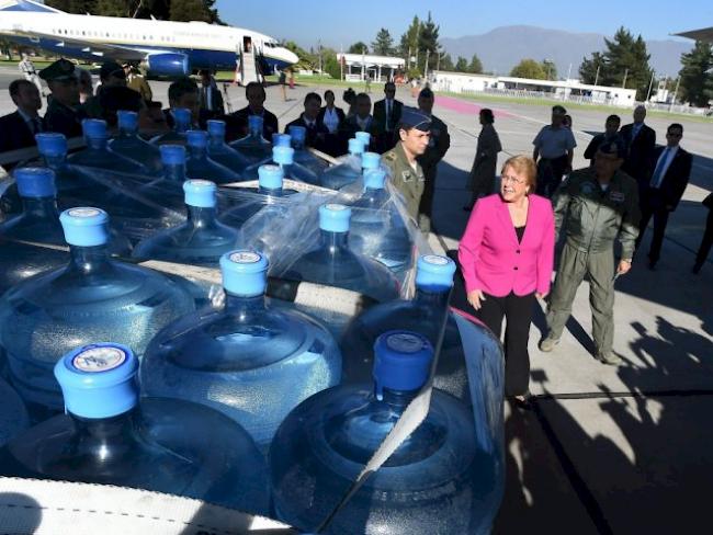 Chiles Präsidentin begutachtet Trinkwasserlieferung für Flutopfer