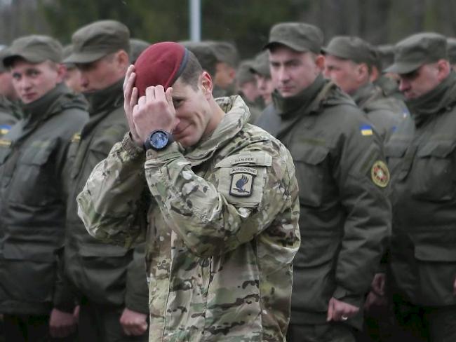 Ein US-Soldat vor Mitgliedern der ukrainischen Nationalgarde