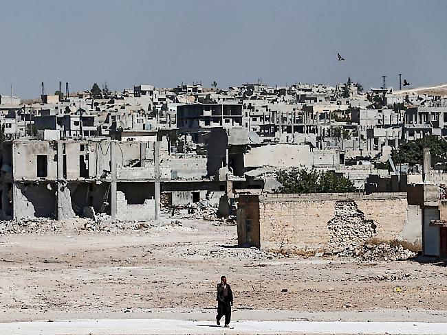 Ein Mann vor zerstörten Häusern in Kobane (Archiv)
