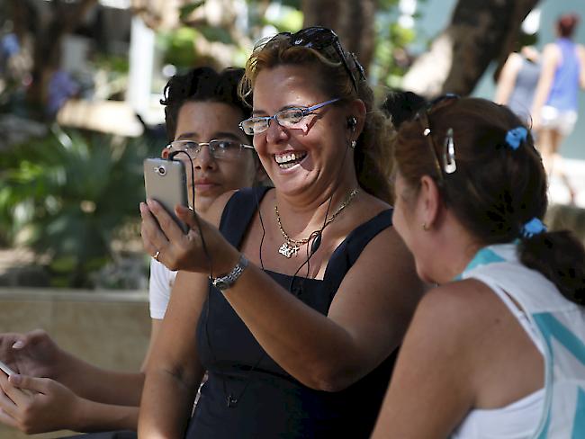 Kubanische Frauen nutzen einen öffentlichen Wlan-Spot, um mit Verwandten in Kanada zu chatten. (AP Photo/Desmond Boylan)