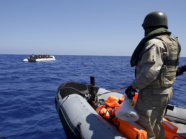 Ein belgischer Soldat fährt zu einem Boot mit Flüchtlingen, um diese in Sicherheit zu bringen. (Archiv)