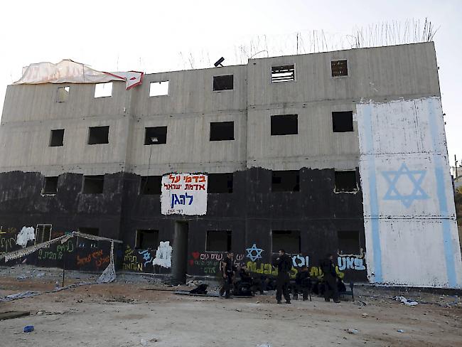 Sicherheitskräfte vor einem Haus jüdischer Siedler, dass abgerissen werden soll. Israels Ministerpräsident Netanjahu erlaubte nun den Bau weiterer Wohnungen für Siedler.