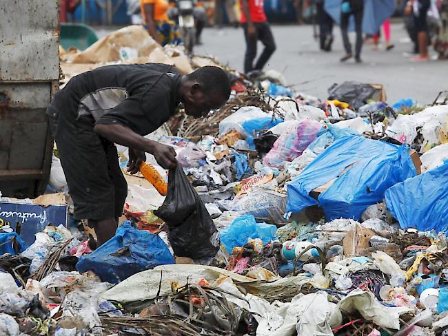 UNO will Armut beenden: Mann in Liberia durchsucht einen Abfallberg