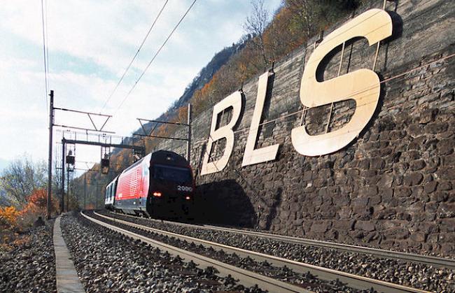 Ein Personenzug fährt auf der Südrampe zum Lötschberg zwischen Goppenstein und Brig an einem BLS-Logo vorbei (Archiv)