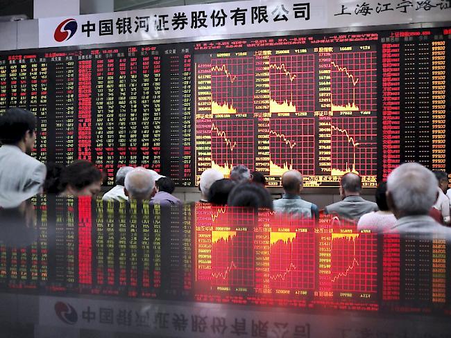 Gebannte Blicke auf die Kurstafel einer Börse in Shanghai: Auch am Dienstag stiegen die Aktien mit Verlusten in den Handel. (Archivbild)