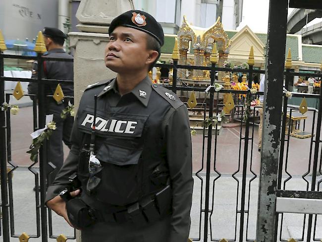 Ein Polizist am Erawan-Schrein im belebten Einkaufsviertel Bangkoks, wo bei einer Explosion vor zwei Wochen 20 Menschen gestorben waren (Archiv)