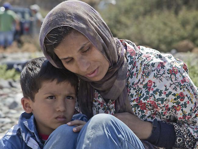 Eine Migrantin aus Afghanistan mit ihrem Sohn am Strand von Eftalou im Norden der griechischen Ägäisinsel Lesbos. Die Flüchtlinge hoffen, von Lesbos aus ans Festland zu gelangen. Von dort wollen sie über die Balkanroute nach Westeuropa (Archiv)