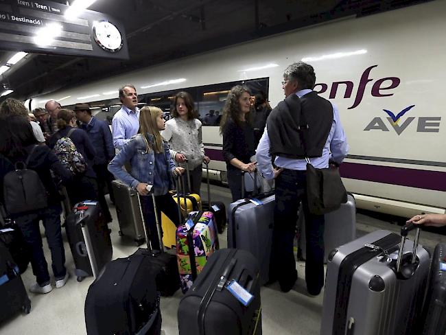 Passagiere warten am Donnerstag bei einem Hochgeschwindigkeitszug im Bahnhof Sants in Barcelona.