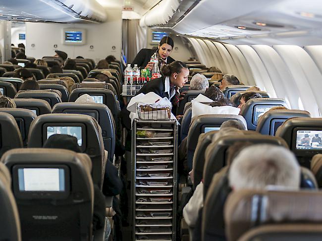 Zwei Flugbegleiterinnen bedienen in einem gut gefüllten Swiss-Flugzeug Passagiere der Economy Class. In den ersten neun Monaten des Jahres hat die Fluggesellschaft mehr Passagiere angezogen als noch im Vorjahr. (Archiv)