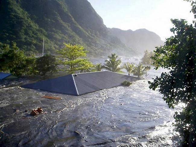 In Apia, der Hauptstadt des pazifischen Inselstaates Samoa, wird im September 2009 ein Hausdach von einer Tsunami-Welle fortgespült (Archiv)