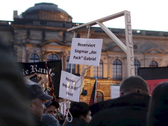 Pegida-Anhänger tragen bei einer Demo in Dresden einen für die deutsche Kanzlerin Merkel und Vizekanzler Gabriel reservierten Galgen mit sich - nun ermittelt die Justiz. (Archiv)