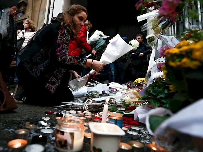 Im Gedenken an die fast 130 Opfer der Anschläge von Paris am 13. November legen Menschen vor dem Bataclan Blumen nieder. Alleine in der bekannten Konzerthalle starben 90 Menschen.