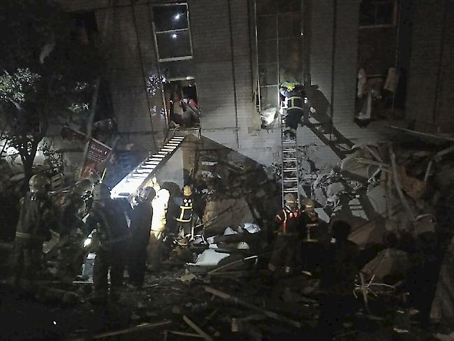 Rettungskräfte in der taiwanesischen Stadt Tainan bergen nach dem Erdbeben Verschüttete aus einem Wohngebäude.