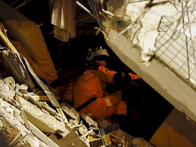 Kein Innehalten auch während der Nacht: Im vom Erdbeben zerstörten Hochhaus in der taiwanesischen Stadt Tainan suchen Rettungskräften nach Opfern.