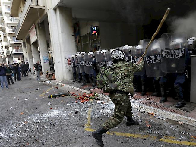 Ein wütender Demonstrant attackiert Polizisten vor dem Landwirtschaftsministerium in Athen.