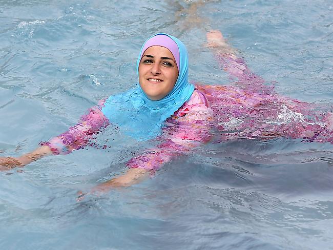 Eine junge Muslimin geniesst ein Bad im Burkini. (Archiv)