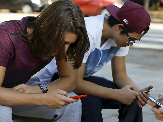 Jugendliche in Sao Paulo widmen ihre volle Aufmerksamkeit ihrem Smartphone: Brasilien hatte eine dreitägige Sperre des Nachrichtendienstes WhatsApp angeordnet. Ein Gericht verfügte nun, dass diese Blockade aufgehoben werden muss. (Symbolbild)