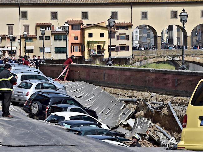 Ein Feuerwehrmann begutachtet das abgesackte Strassenstück beim "Ponte Vecchio".