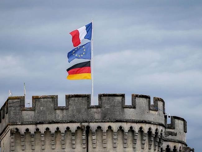 Die Flaggen von Frankreich, Europa und Deutschland wehen auf dem Zolltor von Verdun. Der Name der lothringischen Stadt steht für eine der tödlichsten Schlachten des Ersten Weltkriegs.