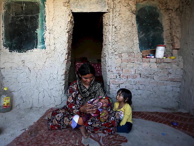 Eine Mutter mit ihren Kindern in einer temporären Unterkunft für Binnenflüchtlinge in Afghanistan.