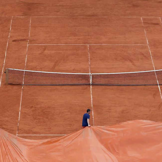 Ein Platz in Roland Garros wird mit einer Blache überdeckt