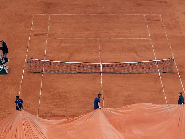 Ein Platz in Roland Garros wird mit einer Blache überdeckt