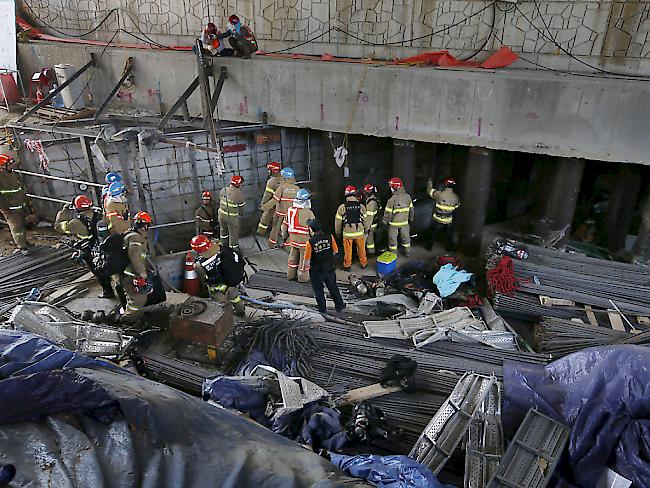Rettungskräfte suchen nach Verschütteten nach einer Explosion in einer U-Bahn-Baustelle in Südkorea.