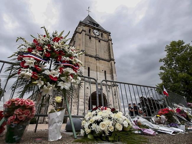 Blumen bei der Saint-Etienne-Kirche nahe Rouen, wo zwei Angreifer einen Priester ermordeten. Nun ist auch der zweite der beiden Täter offiziell identifiziert worden.