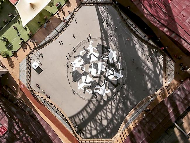Cleon Petersons Strassengraffito unter dem Eiffelturm beschwört die Einigkeit der Menschen. (Instagram)