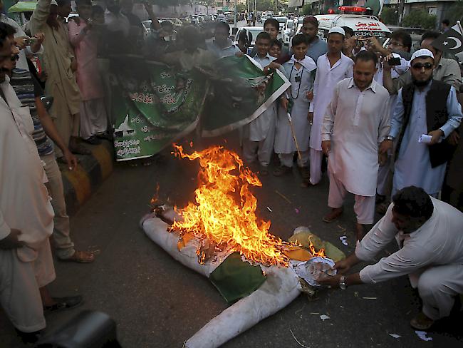 Pakistanische Demonstranten verbrennen eine Strohpuppe, die den indischen Premierminister Narendra Modi darstellen soll. Die Situation an der Grenze zwischen den beiden Atommächten hat sich gefährlich zugespitzt.