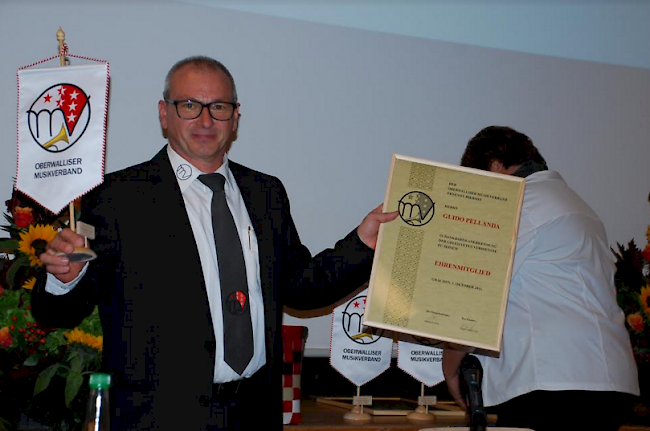 Der scheidende Präsident Guido Pellanda mit Verbandsstandarte und Ehrenurkunde.