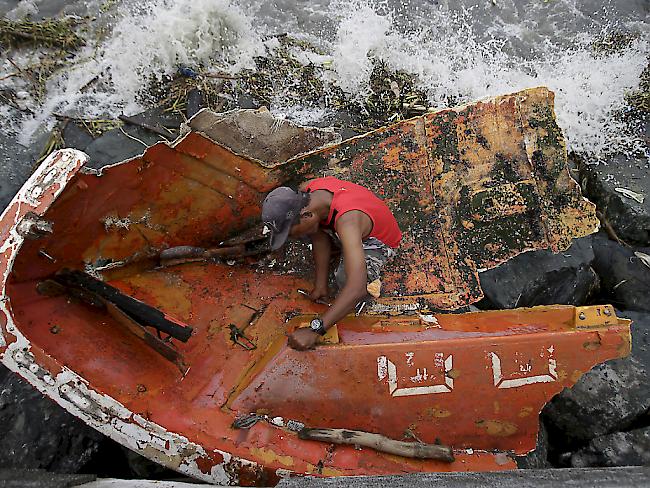 Ein Mann sammelt das Metall eines zerstörten Bootes, das der Taifun Haima bei Manila an Land schwemmte.