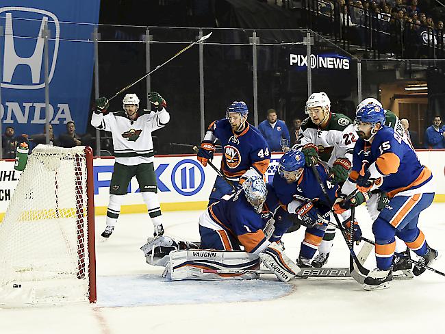 Nino Niederreiter (Mitte) stochert im Duell zwischen den New York Islanders und den Minnesota Wild den Puck zum 3:5 ins Tor