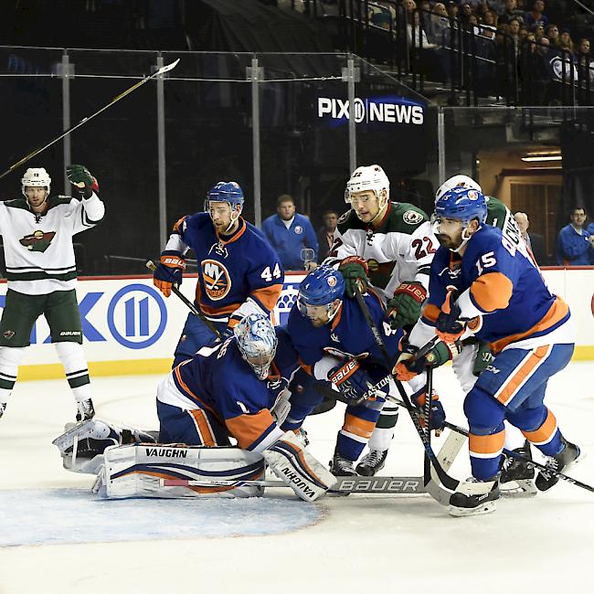 Nino Niederreiter (Mitte) stochert im Duell zwischen den New York Islanders und den Minnesota Wild den Puck zum 3:5 ins Tor