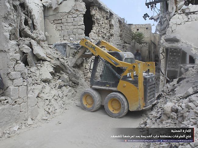 Arbeiter räumen nach Luftschlägen in Aleppo Trümmer weg.