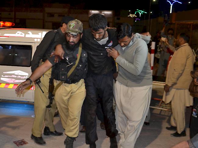 Rettungskräfte bringen einen Verletzten in Sicherheit nach dem Überfall auf eine Polizeischule in Pakistan.