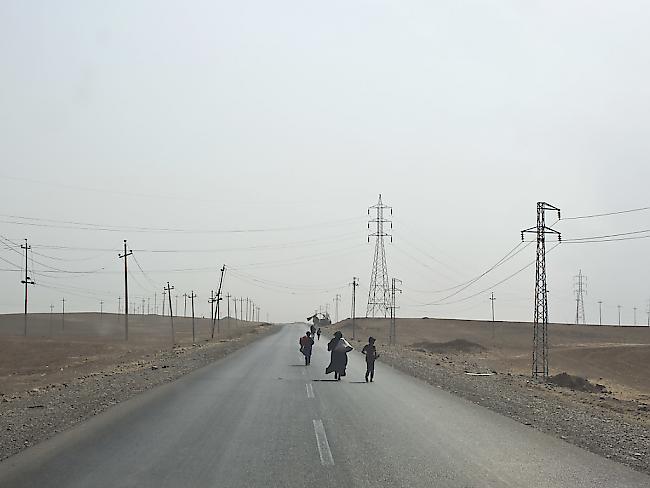 Aus ihren Dörfern vertriebene Menschen auf einer Strasse in der Nähe von Mossul.
