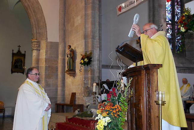Dekan Thomas Michlig übergibt Pfarrer Heiss symbolisch den Schlüssel zur Pfarrei.