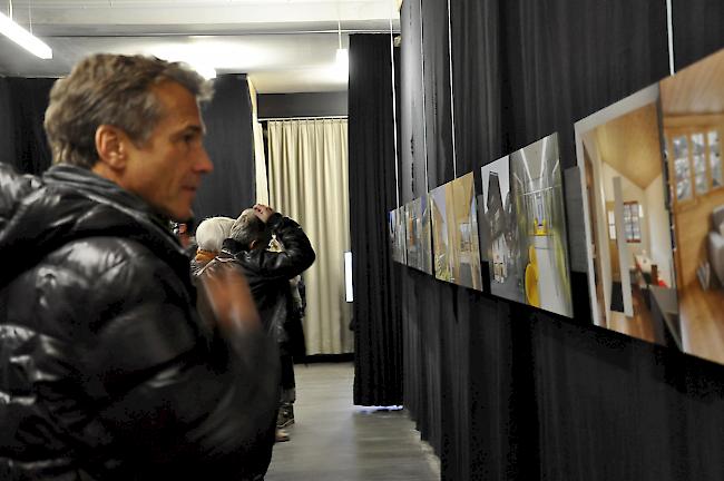 Ein interessierter Besucher mit kritischem Blick auf die Fotos zu den Projekten.