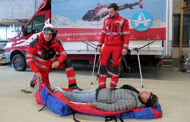 Notarzt und Rettungssanitäter simulieren im Hangar eine Rettung per Winde und Rettungssack. Als Patient stellt sich ein Besucher zur Verfügung.