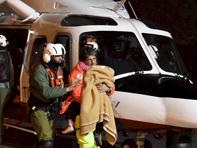 Eines der drei Kinder, die am Freitag aus dem verschütteten Hotel in Italien geborgen wurden, wird ins Spital transportiert. In der Nacht retteten die Bergungsmannschaften drei weitere Menschen.