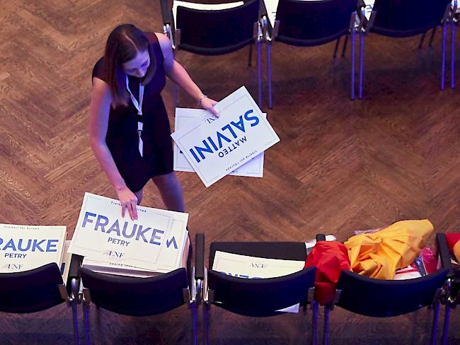 Eine Frau platziert Schilder mit den Namen von Frauke Petry und Matteo Salvini auf Stühle in der Kongresshalle in Koblenz, in welcher das Treffen der bekanntesten Rechtspopulisten Europas stattfindet.