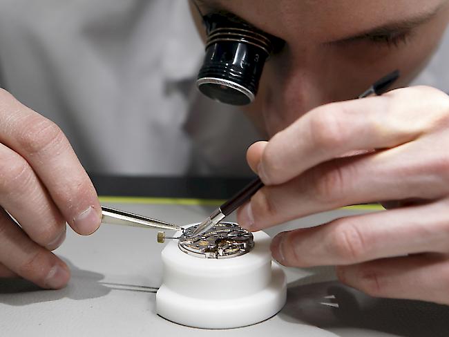 Ein Uhrmacher stellt ein Uhrwerk zusammen. Die Schweizer Uhrenindustrie ist zu Jahresbeginn nicht aus ihrem Tief gekommen. (Symbolbild)
