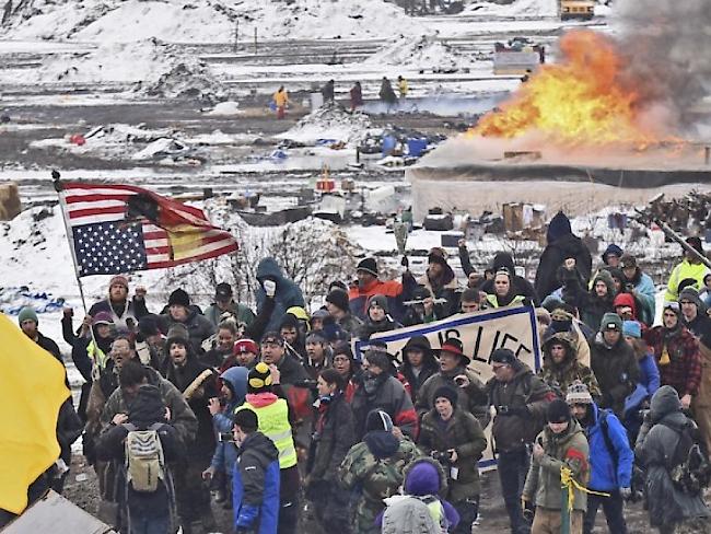 Nach fast einem Jahr ist das Protestlager gegen den Bau einer umstrittenen Ölpipeline im Norden der USA geräumt worden. Die Demonstranten verliessen singend und trommelnd das Protestlager auf der vorgesehenen Pipeline-Route. Dabei setzten sie auch einige ihrer Zelte und Hütten in Brand.