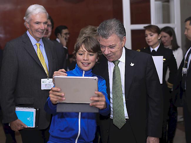 Kolumbiens Präsident Juan Manuel Santos stellt sich einem Jungen für ein Selfie zur Verfügung (Archiv)