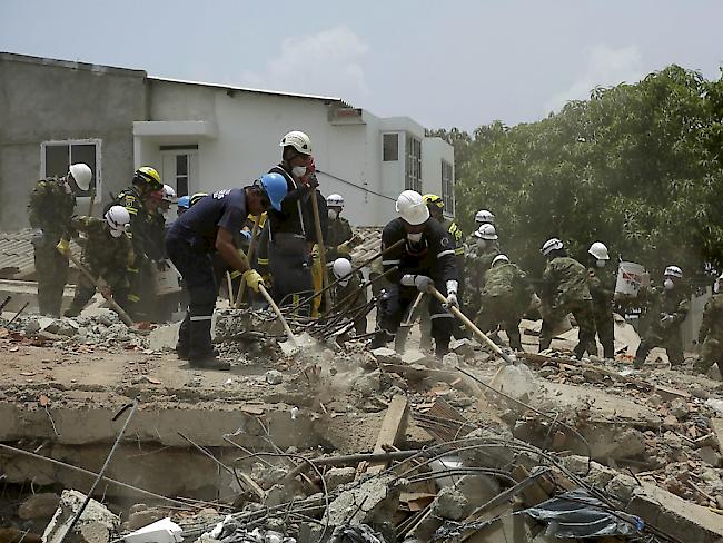 Rettungsarbeiter suchen nach dem Gebäudeeinsturz nach Opfern.