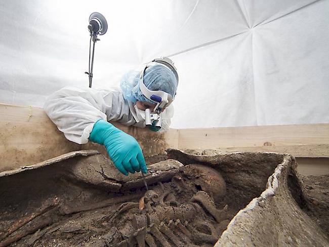 Forschende des Römermuseums Augusta Raurica legen das Skelett der älteren, wohlhabenden Frau im Bleisarg frei.