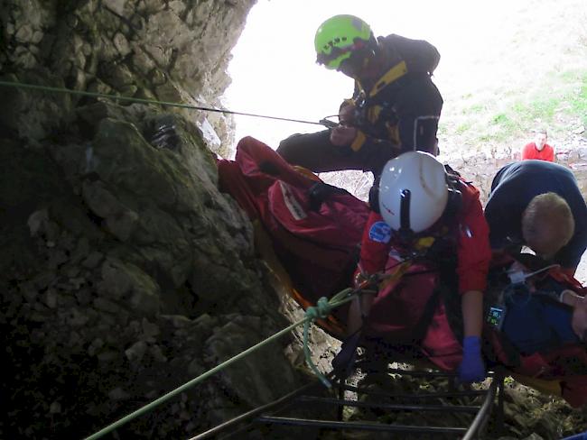 Ein auf der Schrattenfluh in eine Karsthöhle gestürzter Wanderer wird von seinen Rettern zu einem Höhlenausgang abgeseilt.