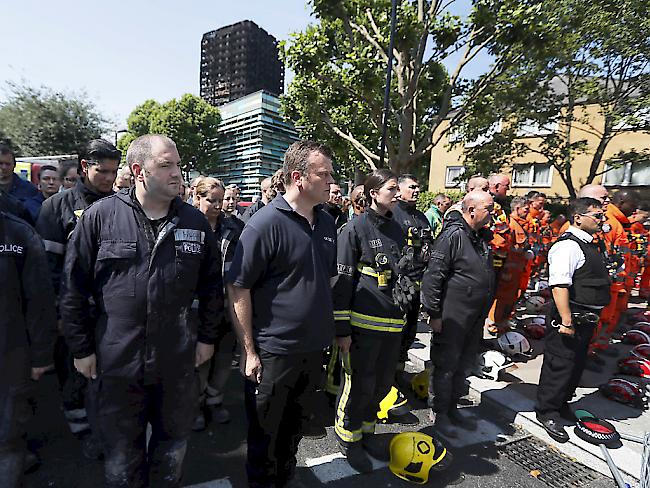 Rettungskräfte beteiligen sich an einer Schweigeminute für die Opfer des Londoner Hochhausbrandes.